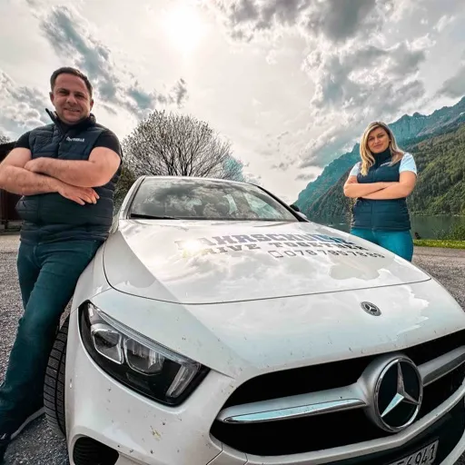 Atila Fetai und Besarta Fetai stehen neben dem Mercedes von Drive Together Fahrschule
